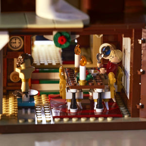 A Brick Apart LEGO Home Alone set interior showing Kevin McCallister at a dining table with candles and a mannequin