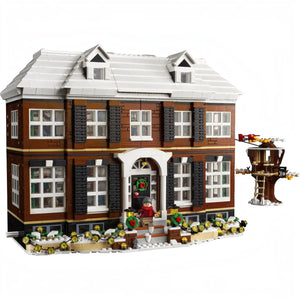A Brick Apart LEGO Ideas Home Alone McCallisters house set with snow-covered roof, tree house, and Kevin minifigure.