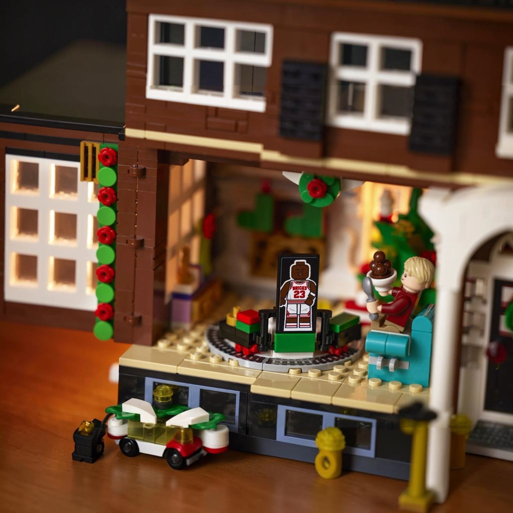 A Brick Apart LEGO Ideas Home Alone set featuring the McCallister house interior with Kevin minifigure and party scene
