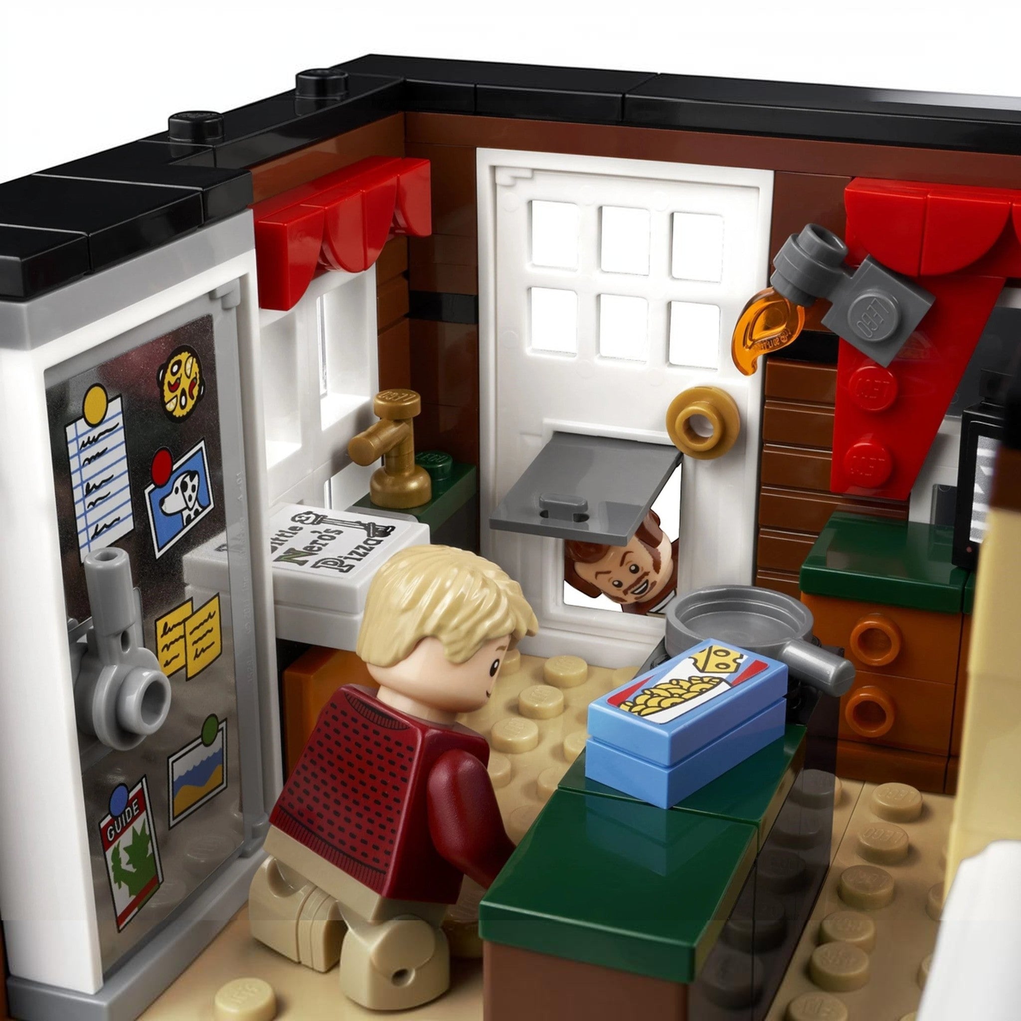 A Brick Apart LEGO Home Alone set interior featuring Kevin McCallister in the kitchen with Harry peeking through the door