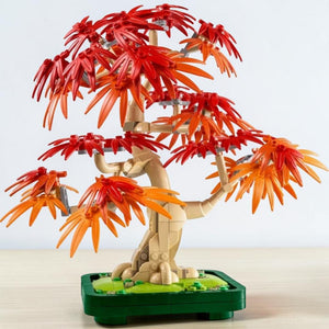 A Brick Apart LEGO Botanicals Japanese Maple Tree with vibrant red and orange leaves in a dark green bonsai pot.