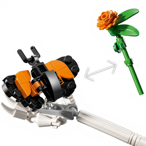 [built-detail] A Brick Apart LEGO Ideas La Catrina set detail showing a brick-built monarch butterfly and an orange marigold flower.
