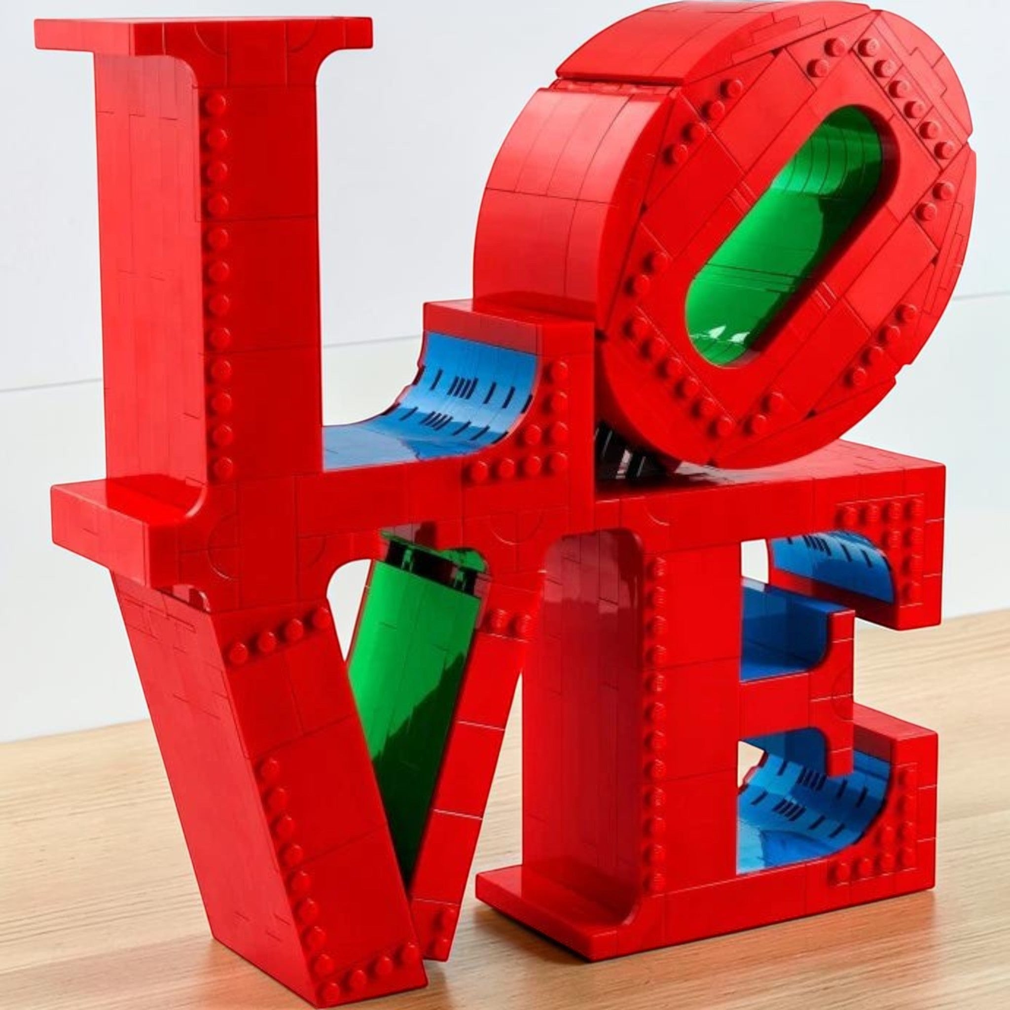 A Brick Apart LEGO Art LOVE sculpture featuring vibrant red, blue, and green bricks in a 3D display model.