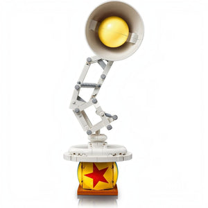 A Brick Apart LEGO Ideas Disney Pixar Luxo Jr. buildable lamp model with a yellow ball featuring a red star.