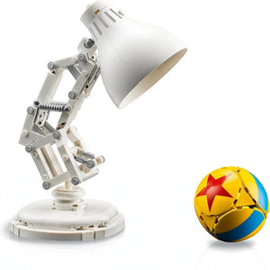 A Brick Apart LEGO Ideas Disney Pixar Luxo Jr. white articulated desk lamp model with a yellow and blue Pixar ball.