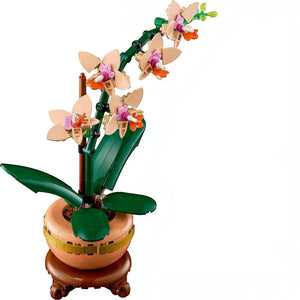 A Brick Apart LEGO Mini Orchid building set featuring peach flowers and green leaves in a terracotta pot on a plinth.