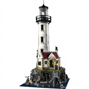 A Brick Apart LEGO Ideas Motorised Lighthouse set featuring a white tower, cottage, and rocky base with minifigures.