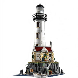 A Brick Apart LEGO Ideas Motorised Lighthouse set featuring a white tower, cottage, and rocky base with two minifigures.