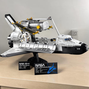 A Brick Apart LEGO NASA Space Shuttle Discovery model with the Hubble Space Telescope and display plaques.