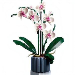 A Brick Apart LEGO Icons Orchid set featuring white and pink flowers in a blue fluted vase with green leaves.