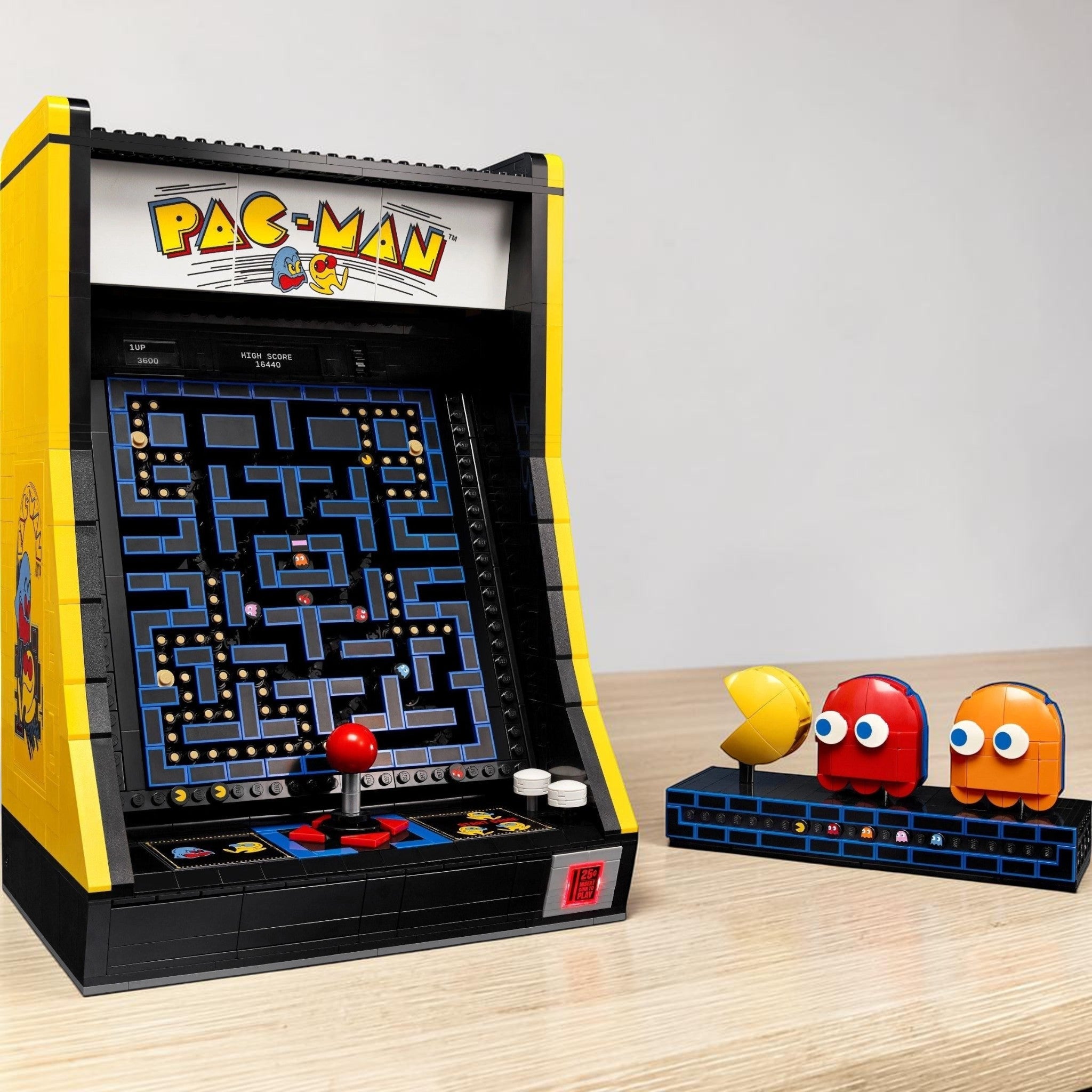 A Brick Apart LEGO Icons PAC-MAN Arcade cabinet with a functional joystick and display stand featuring character figures