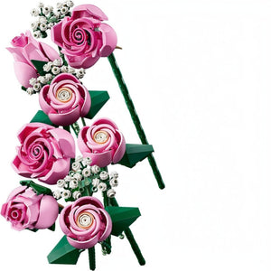 A Brick Apart LEGO Botanicals bouquet featuring pink roses in various bloom stages with white baby's-breath sprigs.
