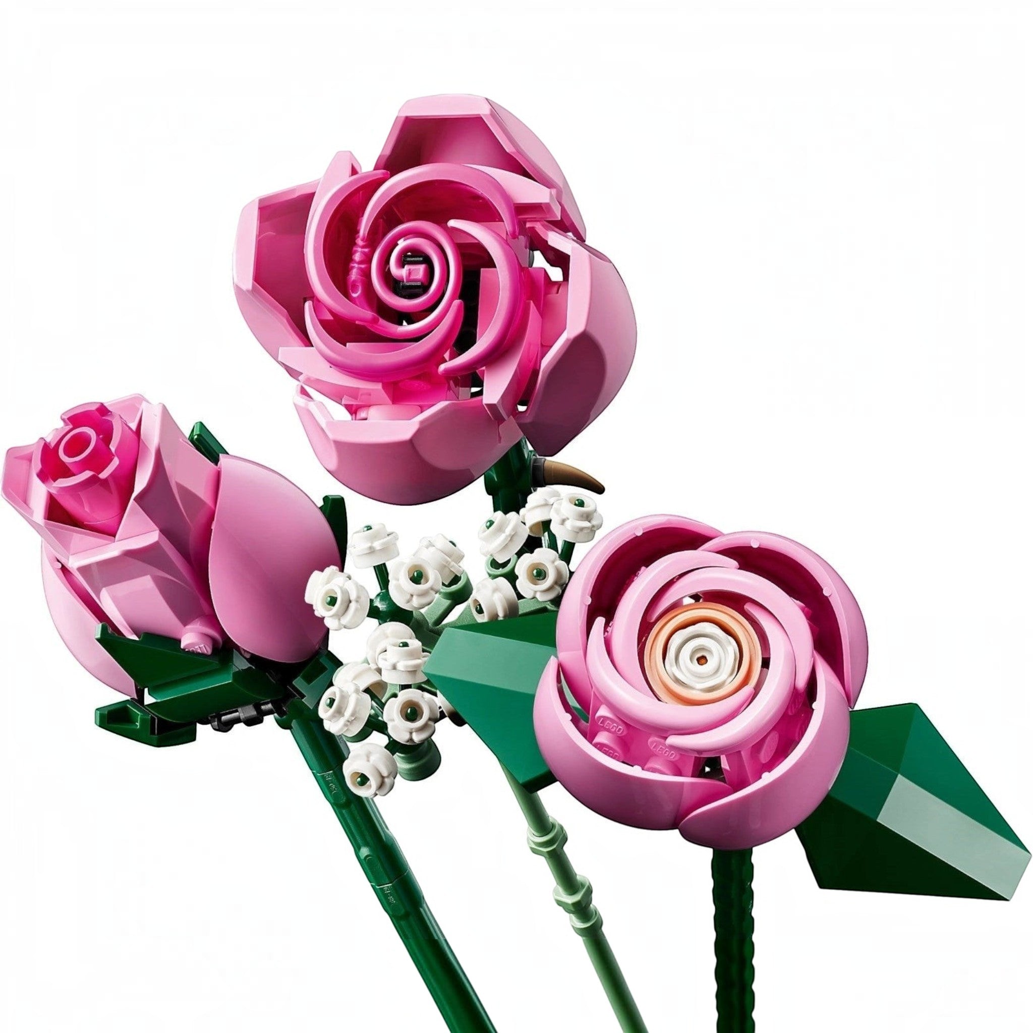 A Brick Apart LEGO Botanicals bouquet featuring three pink roses and white baby's-breath sprigs on green stems.