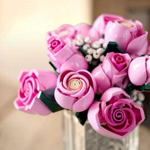 A Brick Apart LEGO Botanicals bouquet featuring pink roses in various stages of bloom with white baby's-breath sprigs.