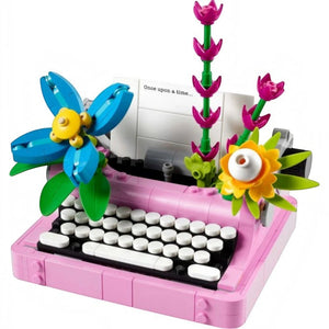 A Brick Apart LEGO Creator typewriter model in pink with colorful brick-built flowers and a paper sheet insert