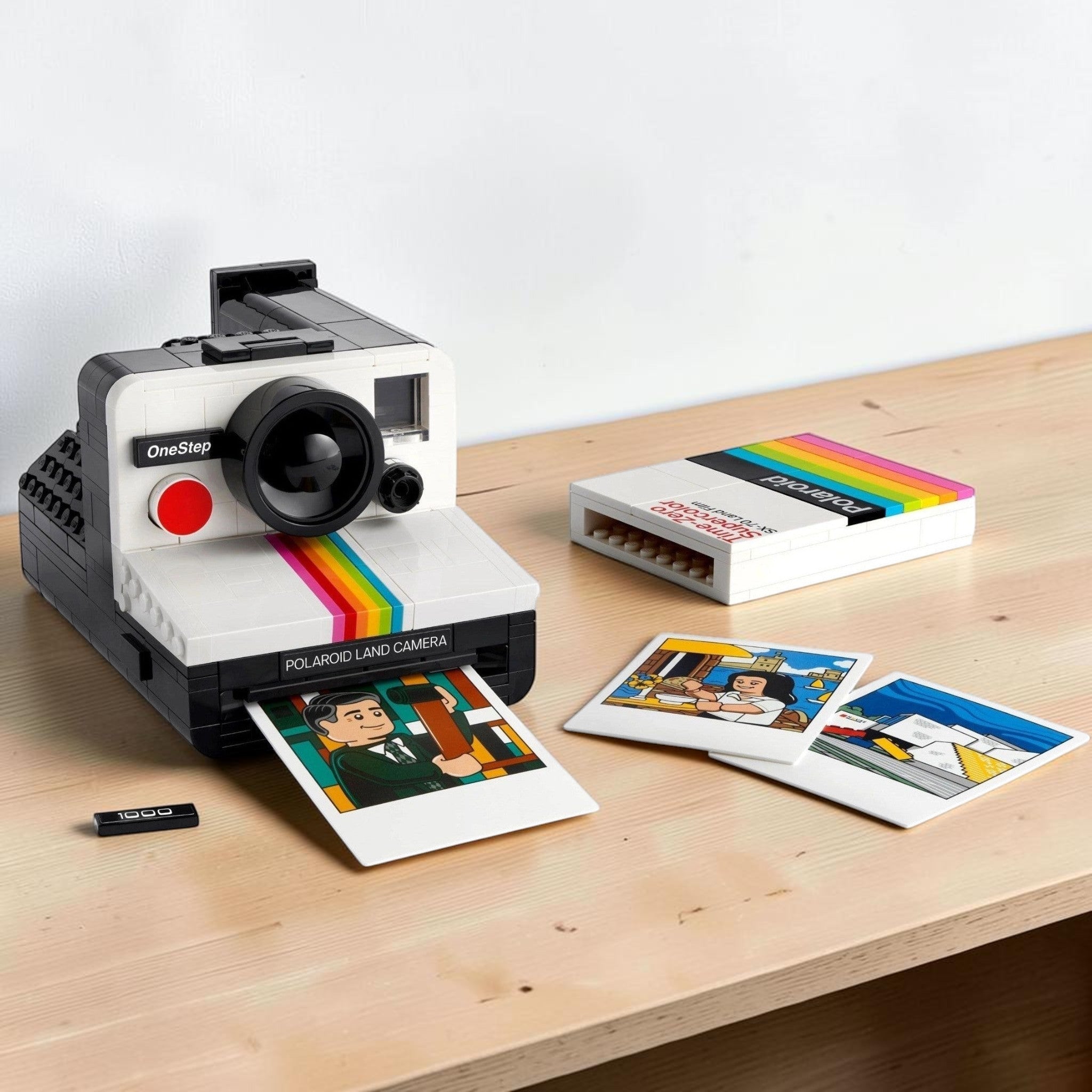 A Brick Apart LEGO Polaroid OneStep SX-70 camera model with a film pack and three illustrated photo prints.