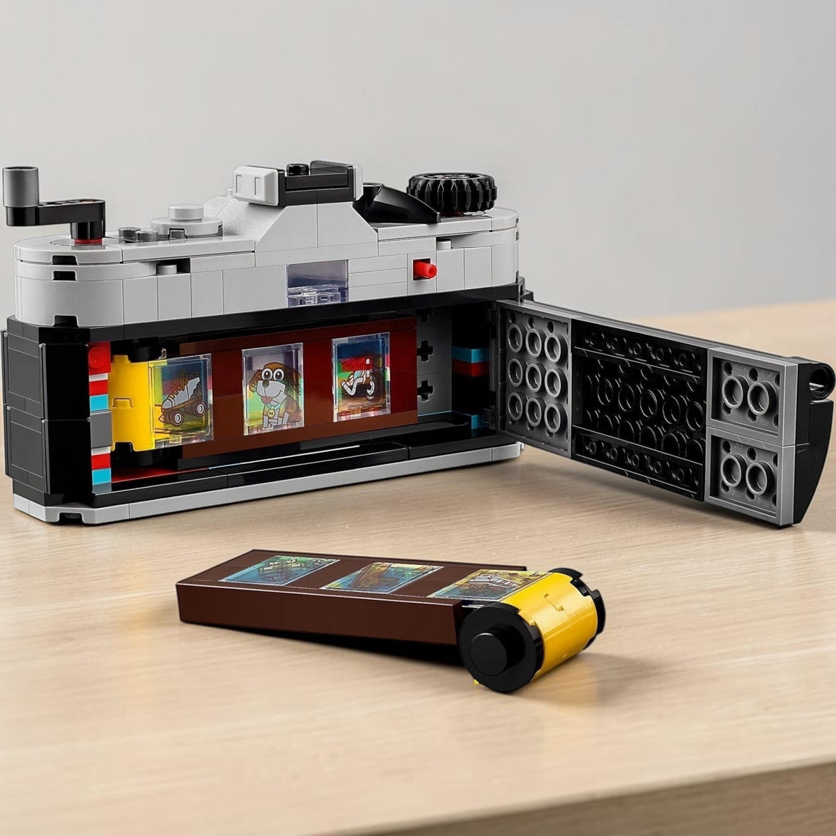 [lifestyle-shelf-built] A Brick Apart LEGO Creator Retro Camera with an open back showing a brick-built film strip with colorful stickers.