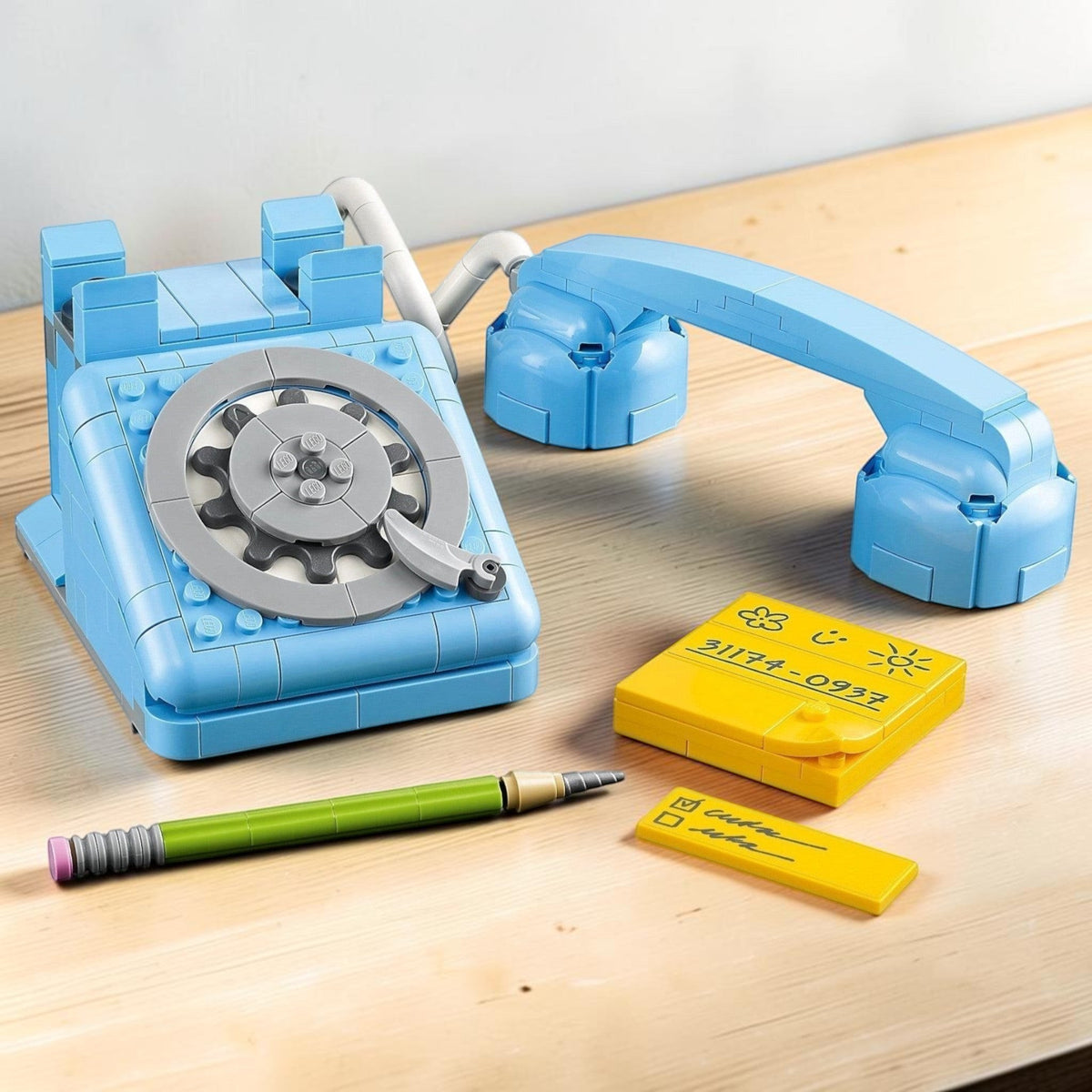 [lifestyle-shelf-built] A Brick Apart LEGO Creator 3in1 light blue retro telephone building set with a rotary dial, receiver, and notepad.