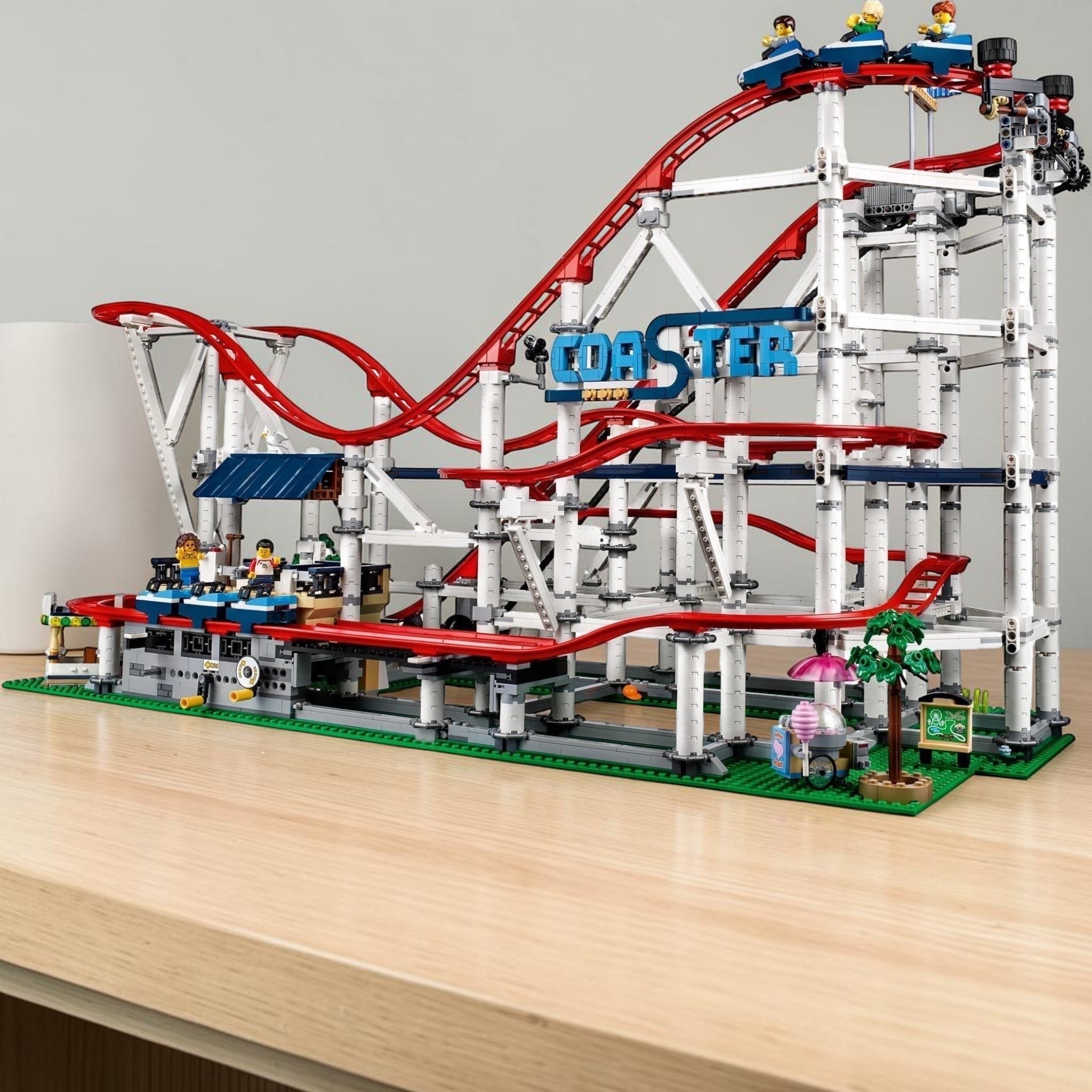 A Brick Apart LEGO Creator Expert Roller Coaster set featuring red tracks, white support beams, and 11 minifigures.