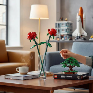 A Brick Apart LEGO Roses set featuring two red brick-built flowers with green stems displayed in a glass vase.