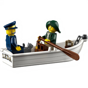 A Brick Apart LEGO minifigures of a lighthouse keeper and sailor rowing a small white boat with a cat