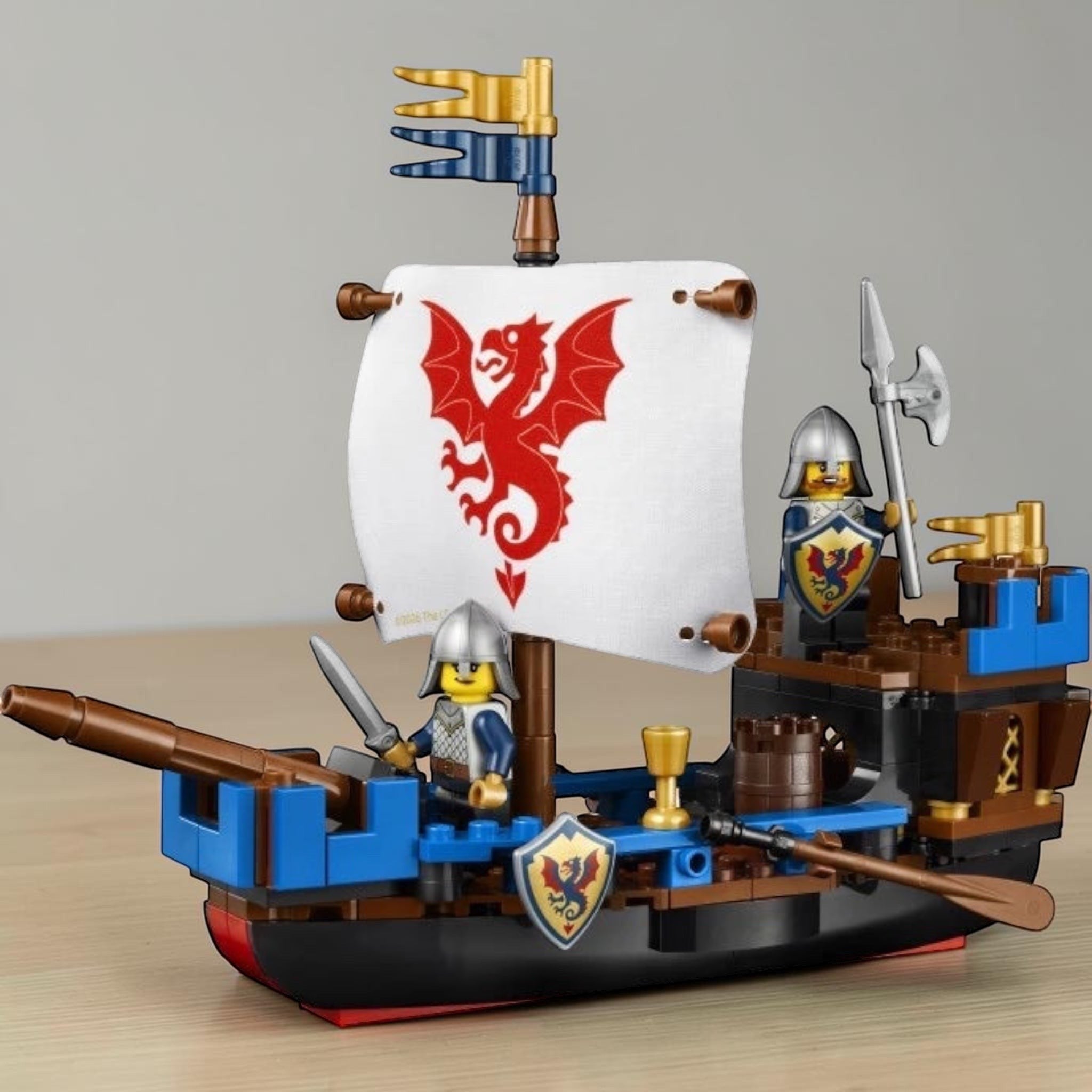A Brick Apart LEGO Ideas Sea Serpent ship model with fabric sail, two knight minifigures, and medieval details.