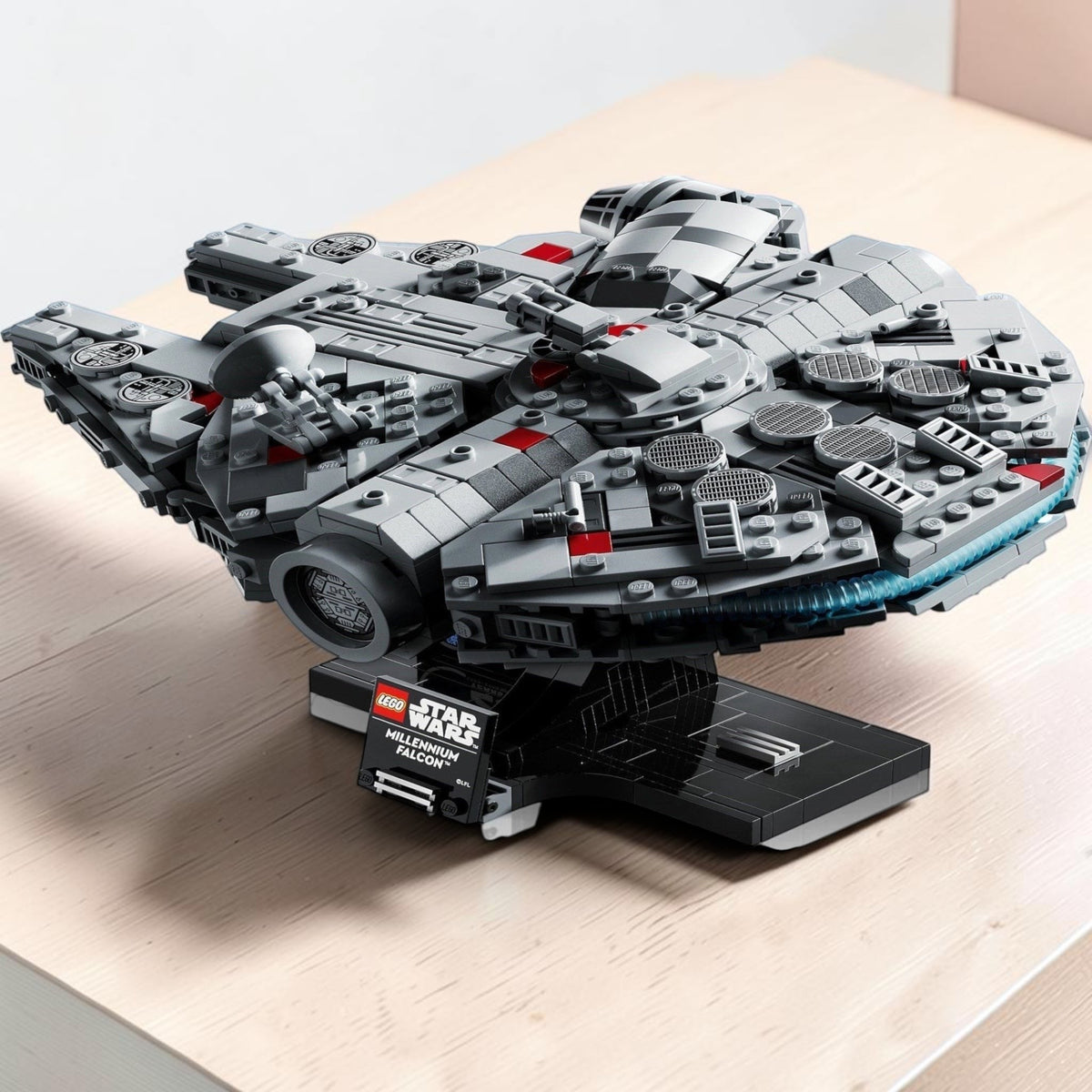 [lifestyle-shelf-built] A Brick Apart LEGO Star Wars Millennium Falcon starship model on a display stand with a 25th anniversary nameplate.