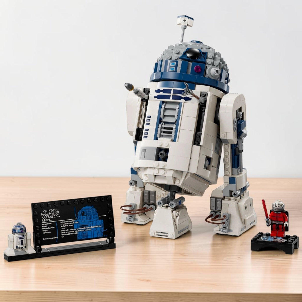 [lifestyle-shelf-built] A Brick Apart LEGO Star Wars R2-D2 display set with a rotating head, third leg, information plaque, and Darth Malak.