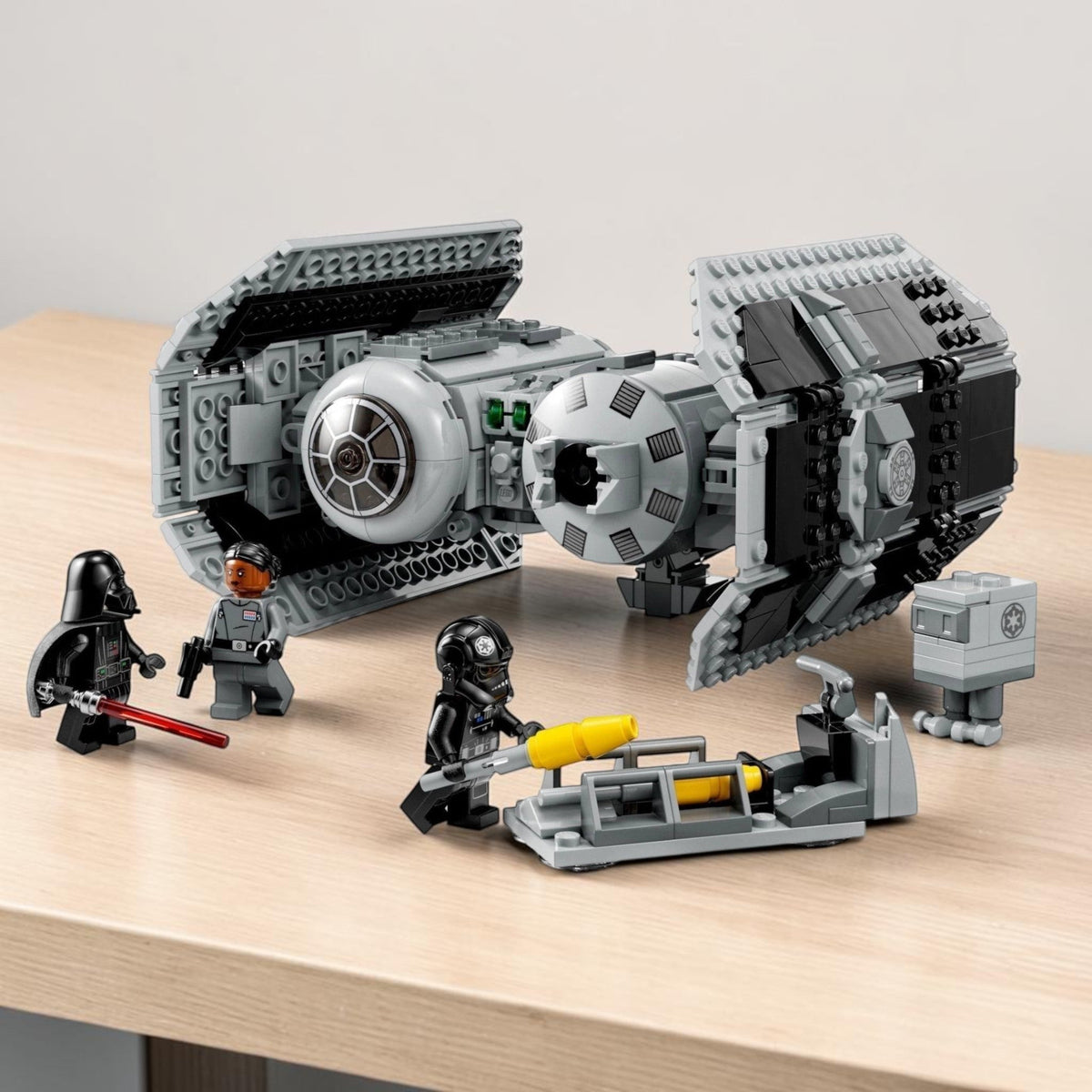 [lifestyle-shelf-built] A Brick Apart LEGO Star Wars TIE Bomber set with minifigures including Darth Vader, TIE Pilot, and a Gonk Droid.