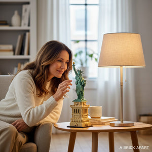 A woman admiring the A Brick Apart LEGO Architecture Statue of Liberty model displayed on a wooden side table.