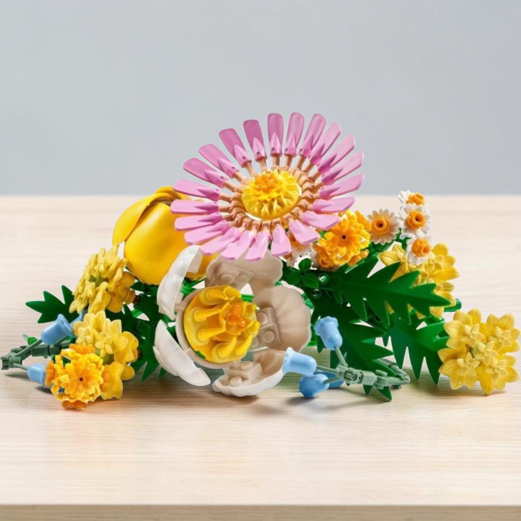 A Brick Apart LEGO Botanicals Petite Sunny Bouquet featuring pastel flowers like pink gerbera, yellow yarrow, and ferns
