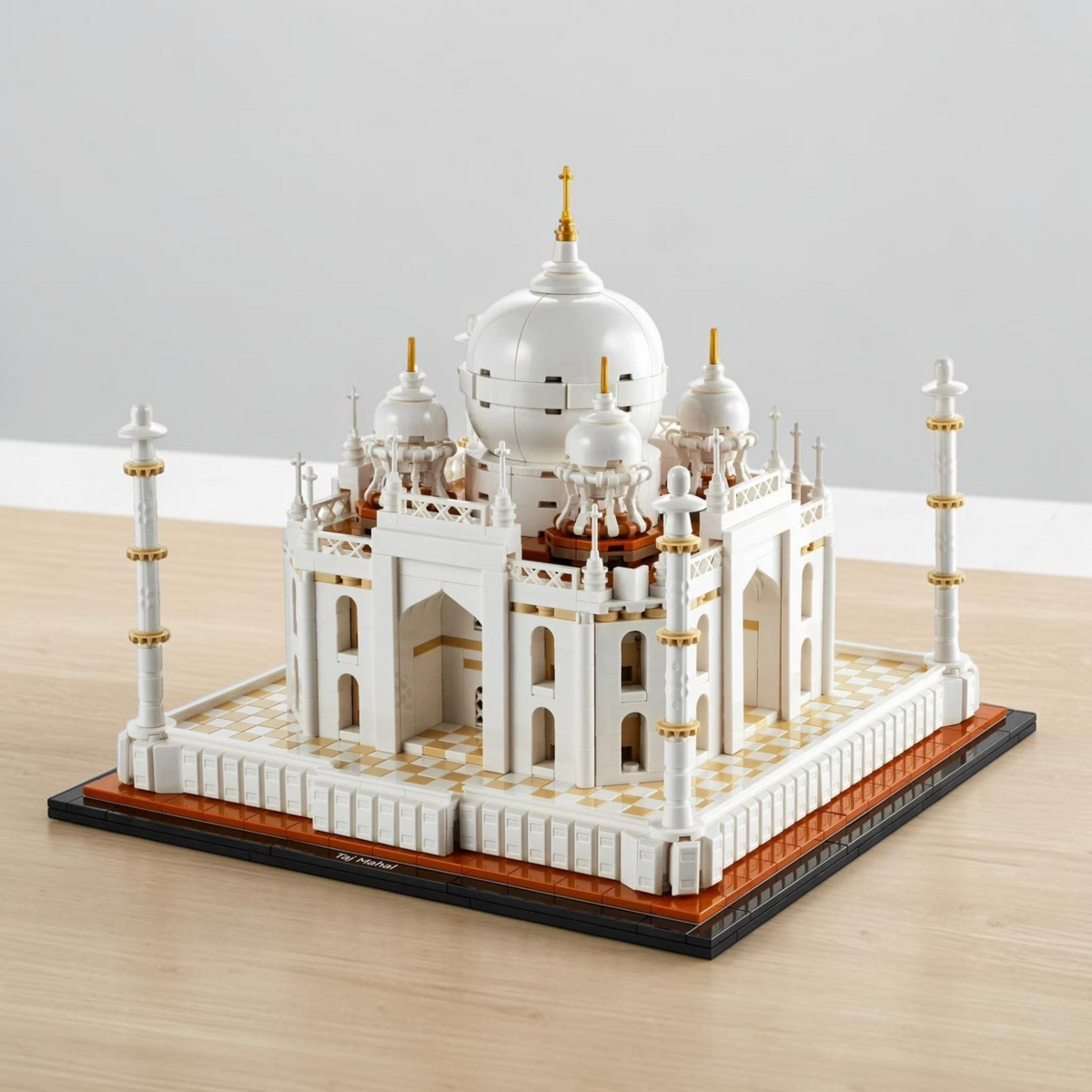 [lifestyle-shelf-built] A Brick Apart LEGO Architecture Taj Mahal model featuring white domes, minarets, and a detailed base on a wooden table.