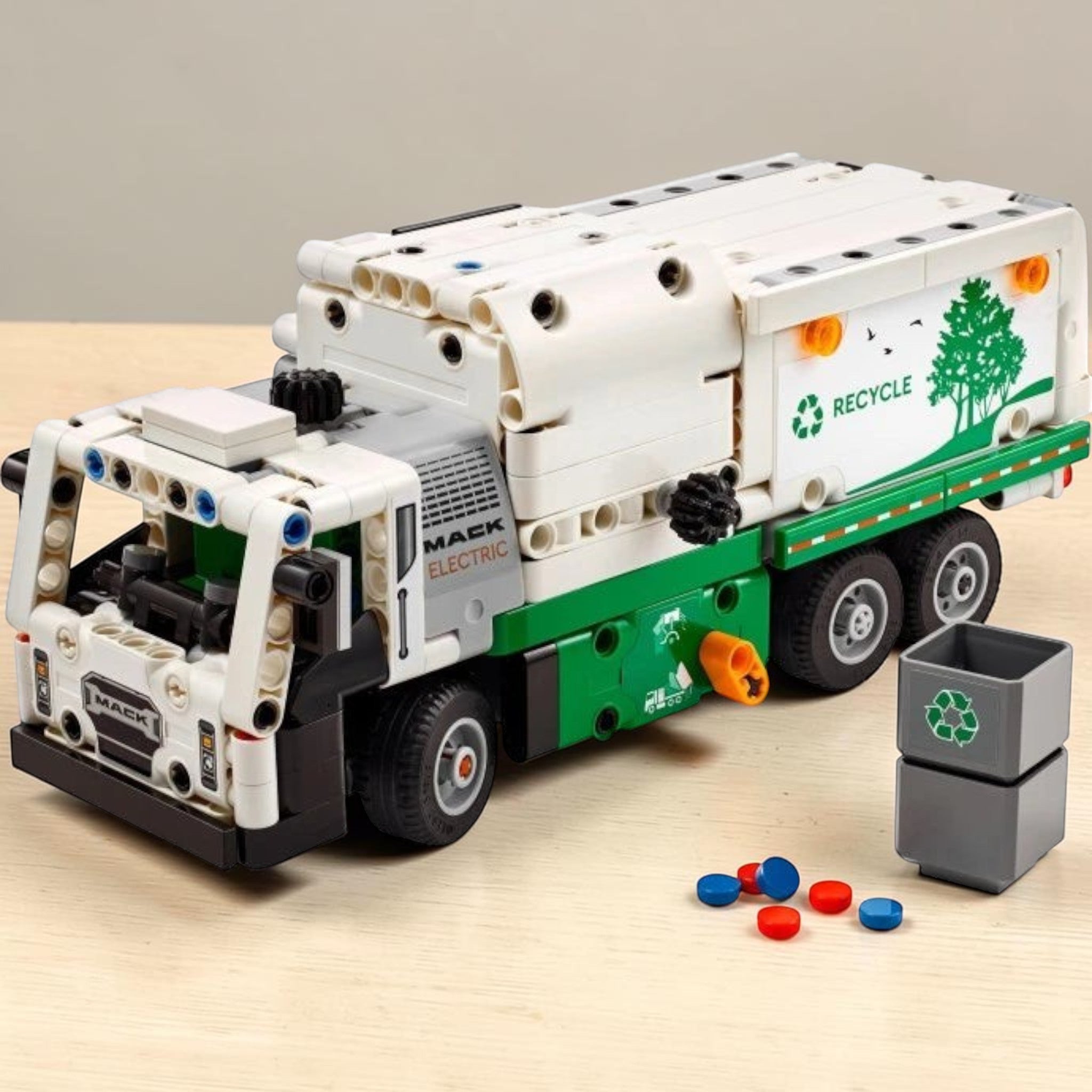 A Brick Apart LEGO Technic Mack LR Electric Garbage Truck with white and green body, side loader, and recycling bin.