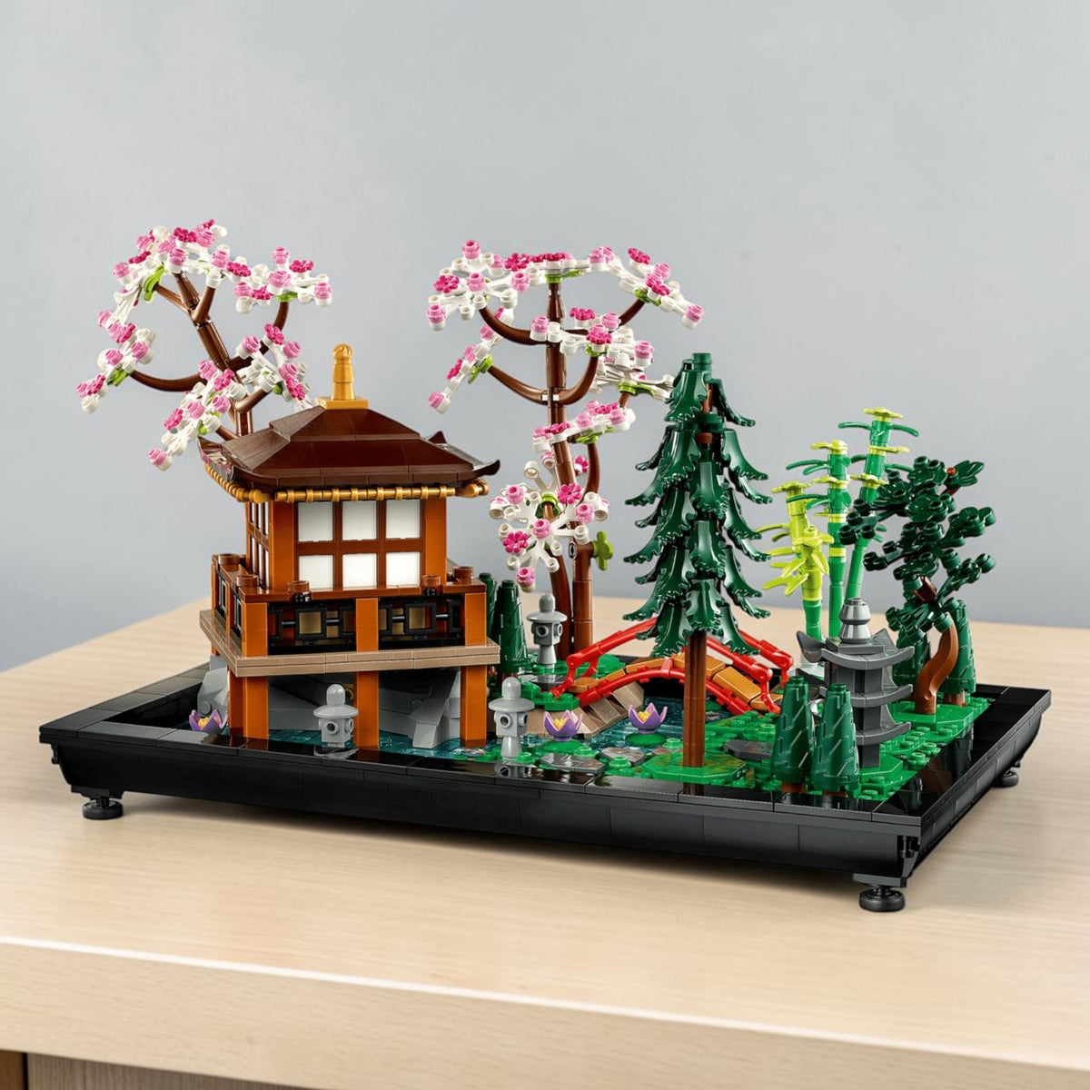 [lifestyle-shelf-built] A Brick Apart LEGO Icons Tranquil Garden set featuring a Japanese pavilion, cherry blossom trees, and arched bridge.