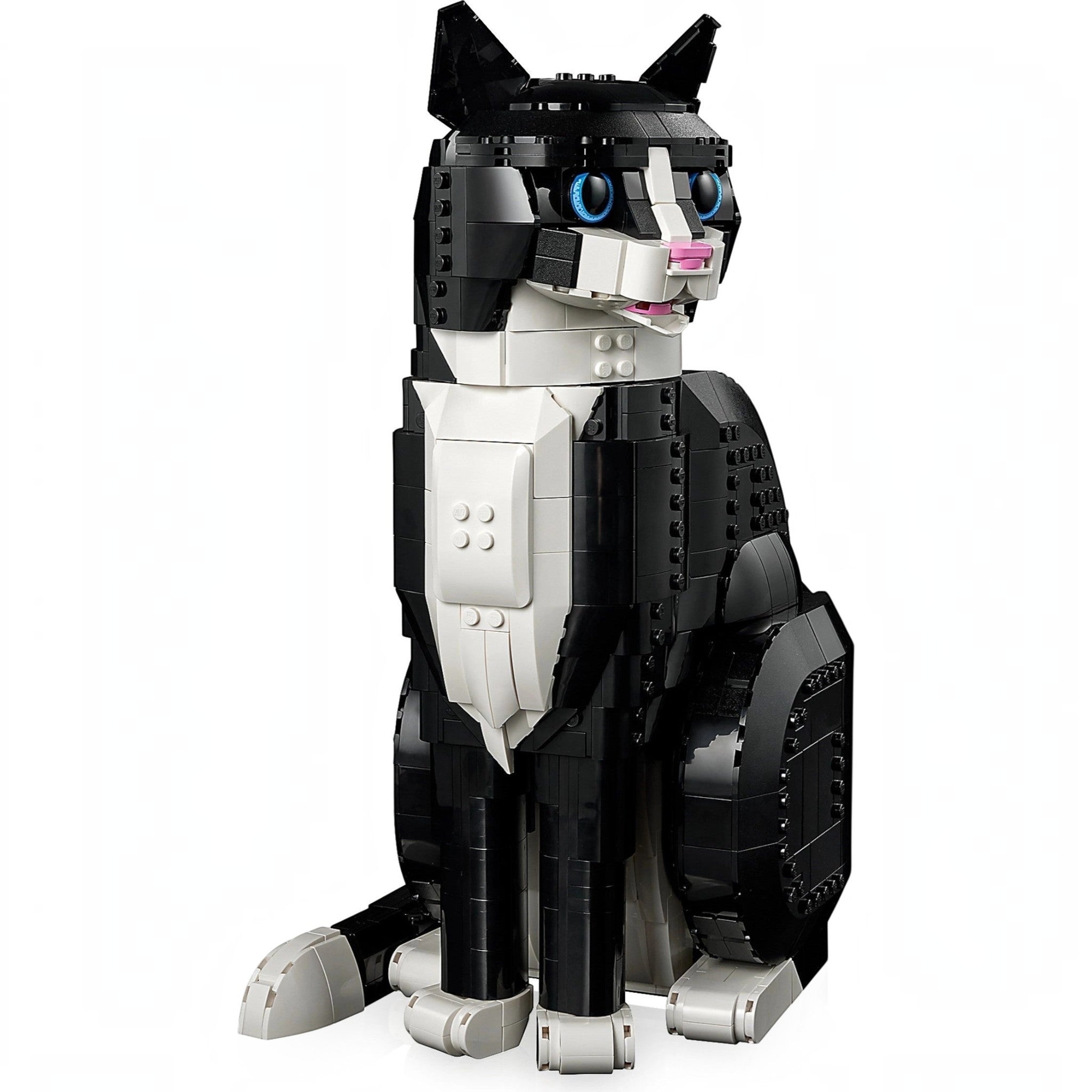 A Brick Apart LEGO Ideas Tuxedo Cat model featuring black and white bricks with bright blue eyes and a pink nose.