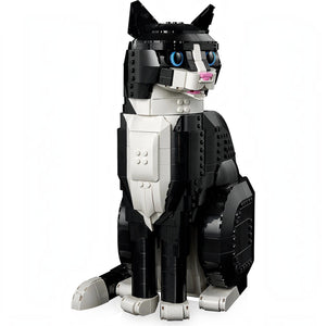 A Brick Apart LEGO Ideas Tuxedo Cat model featuring black and white bricks with bright blue eyes and a pink nose.