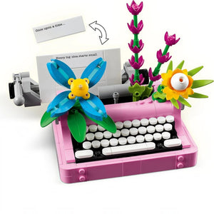 A Brick Apart LEGO Creator typewriter set in pink with colorful brick-built flowers and a paper note on white background