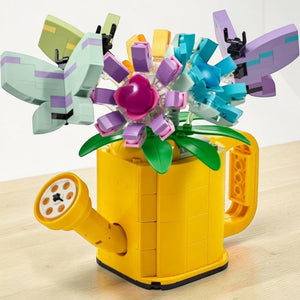A Brick Apart LEGO Creator yellow watering can filled with colorful brick-built flowers and butterflies.