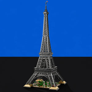 [built-blue-black] A detailed model of the Eiffel Tower built from interlocking blocks, featuring a gray metal lattice structure, a small French flag on top, and a base with green trees and beige accents, set against a split blue and black background.