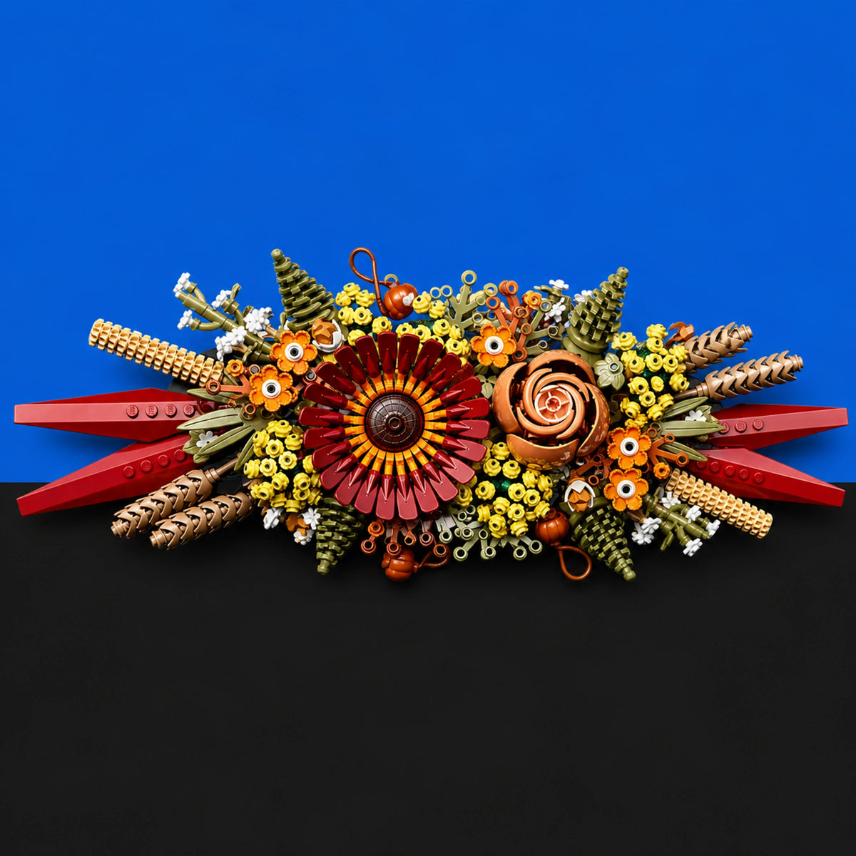 [built-blue-black] A colorful handmade floral arrangement made from pasta, green beans, rice, and small decorative elements, displayed against a split blue and black background.