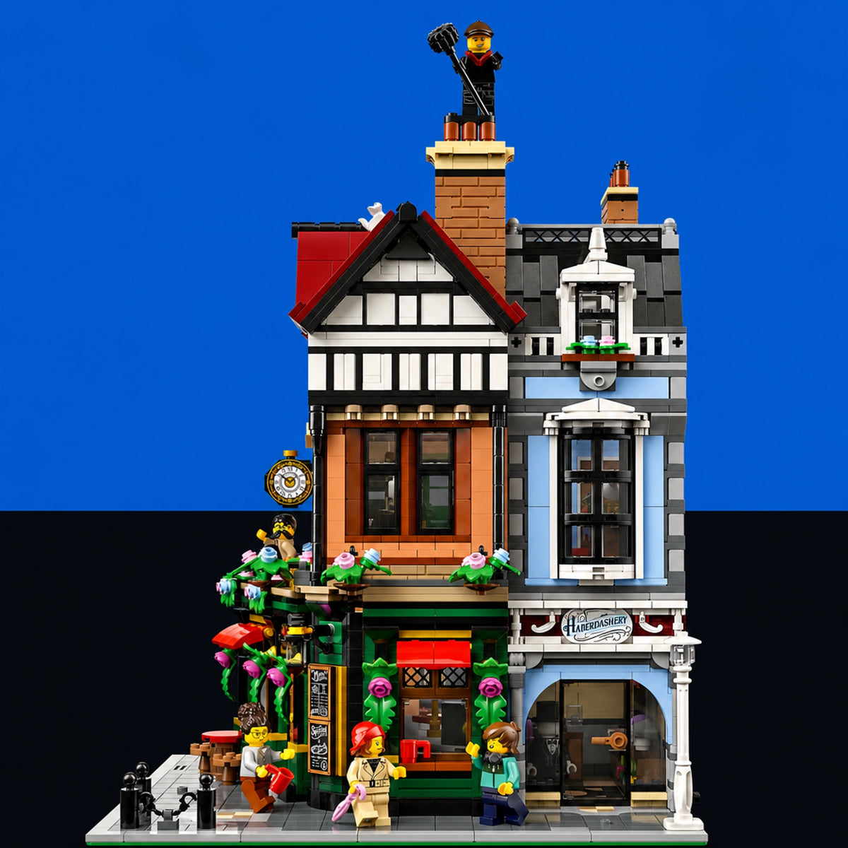 [built-blue-black] A detailed LEGO city building set featuring a two-story shop and residential building with minifigures, set against a split blue and black background.