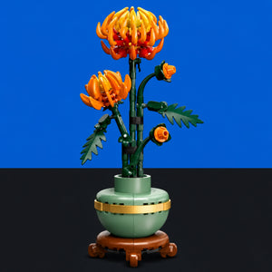 [built-blue-black] A LEGO-style floral vase sculpture with two orange flowers, green stems and leaves, a pale green vase, and a brown pedestal, shown against a blue and black background.