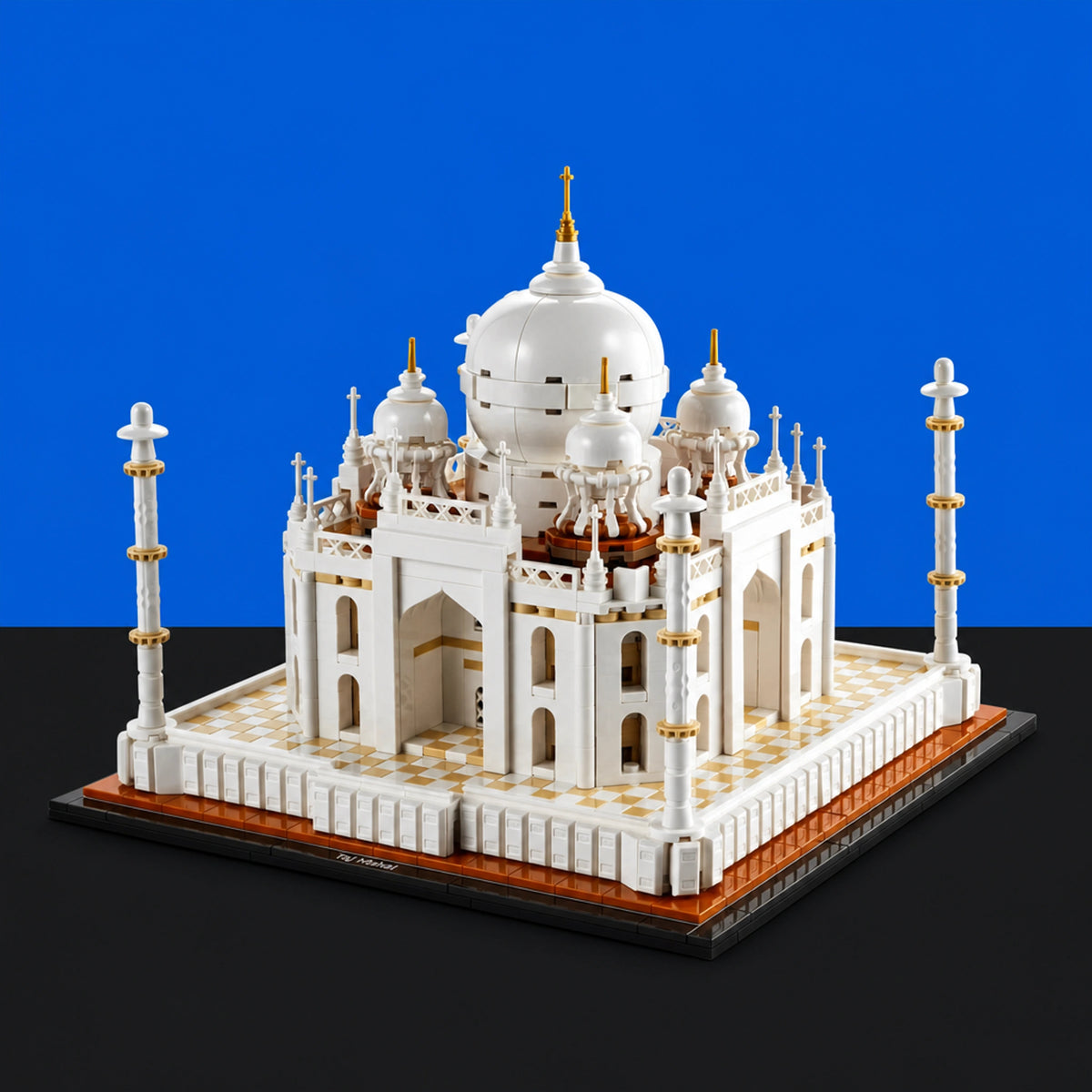 [built-blue-black] A white and gold Taj Mahal model building block structure displayed on a black base against a blue and black background.
