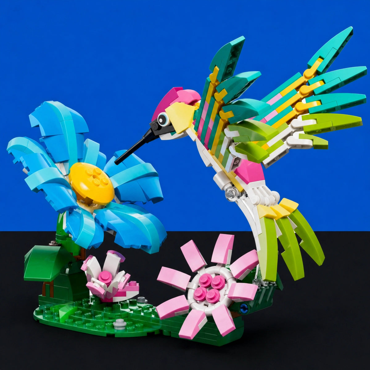 [built-blue-black] A colorful toy bird constructed from building blocks, posed in front of two stylized flowers on a green base against a blue and black background.