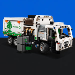 [built-blue-black] A LEGO Technic electric garbage truck model, featuring a white cab and cargo box with green and gray details, set against a solid blue background with a black floor.
