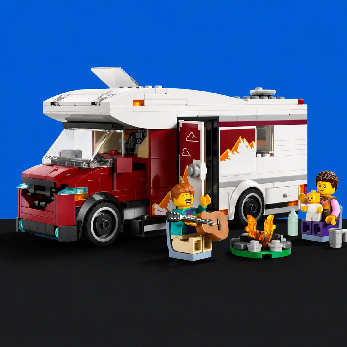 [built-blue-black] A LEGO toy set showing a red and white camper van with a side door open, accompanied by minifigures and camping accessories including a guitar, campfire, and bottles, set against a solid blue background.