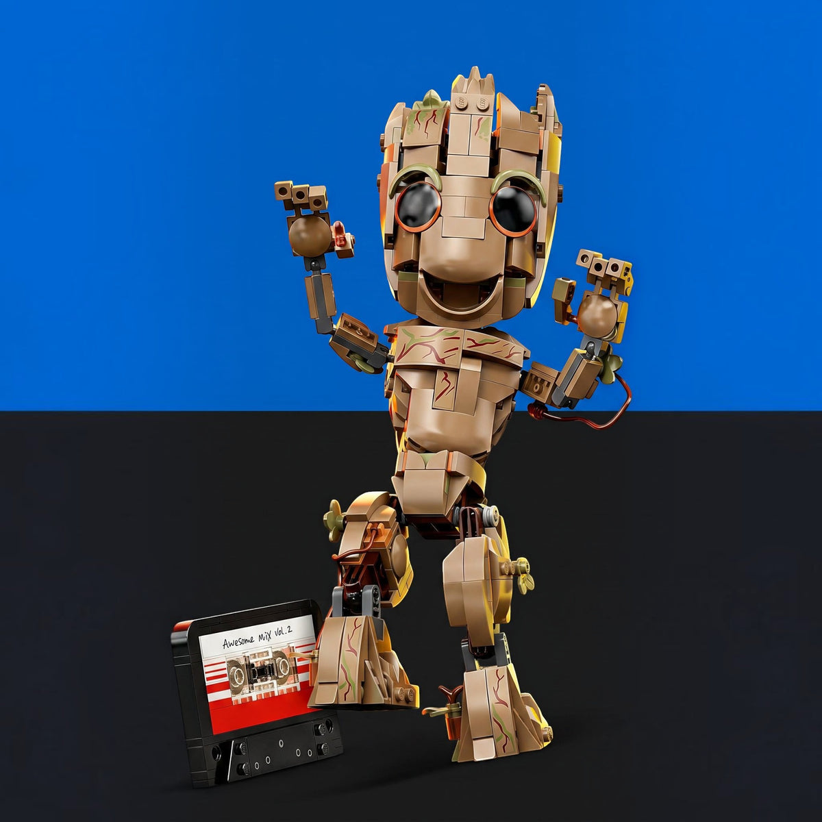 [built-blue-black] A toy figure resembling a small robot or character built from tan and brown blocks, posed against a split blue and black background. A cassette tape accessory labeled 'Avengers: Endgame' sits at the figure's base.