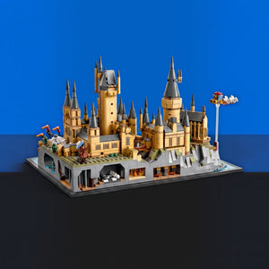 [built-blue-black] A detailed LEGO Harry Potter Hogwarts castle model displayed on a dark gray base against a split blue and black background.