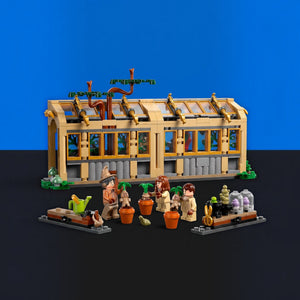 [built-blue-black] A LEGO building set featuring a greenhouse structure with several small minifigures and gardening accessories arranged in front, photographed on a blue and black studio background.