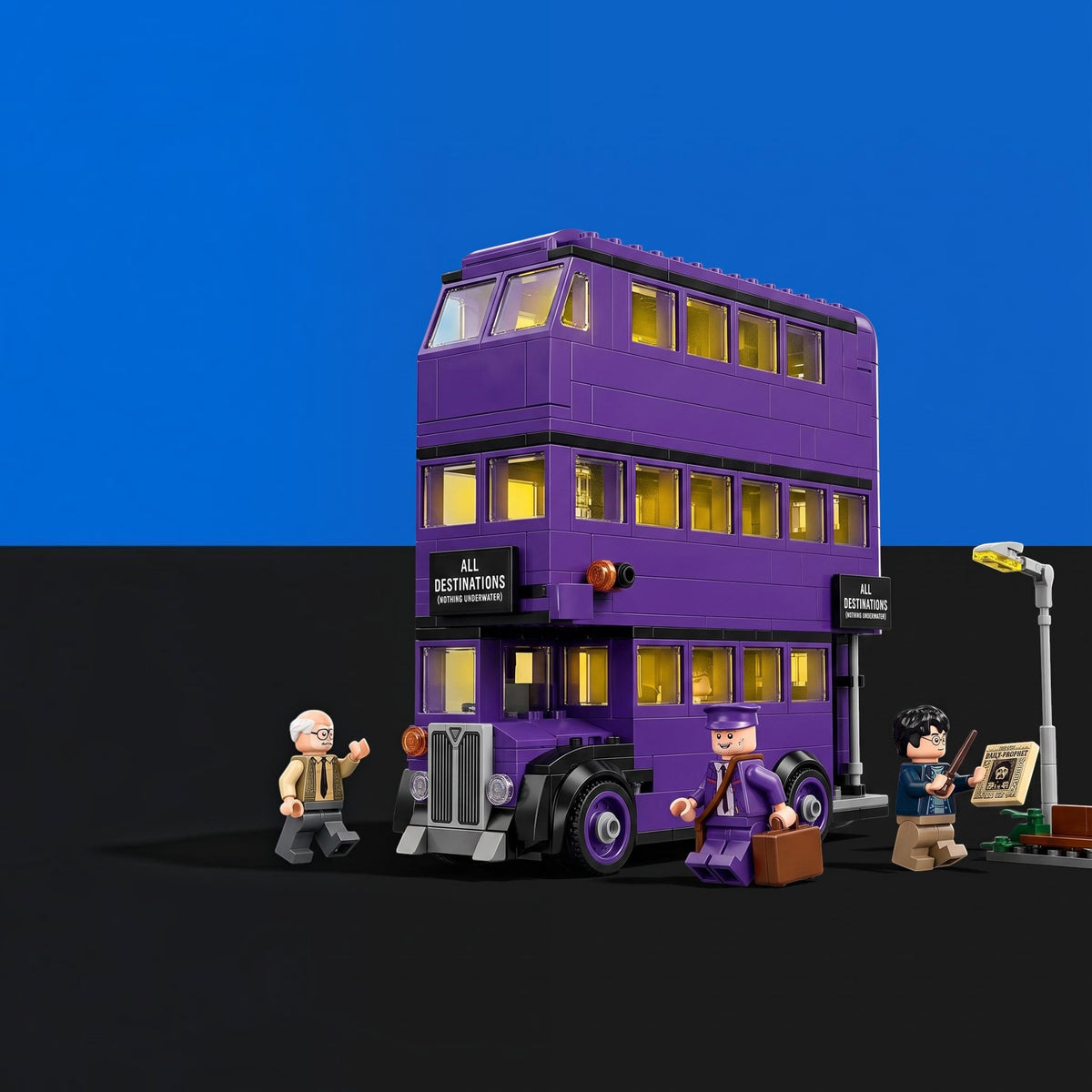 [built-blue-black] A purple triple-decker bus building set with small minifigures and accessories, shown on a black surface against a blue background. The bus has glowing yellow windows and side signs reading 'All Distractions Are Forbidden'.